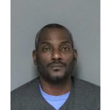 Black man with short salt-and-pepper hair and black facial hair 