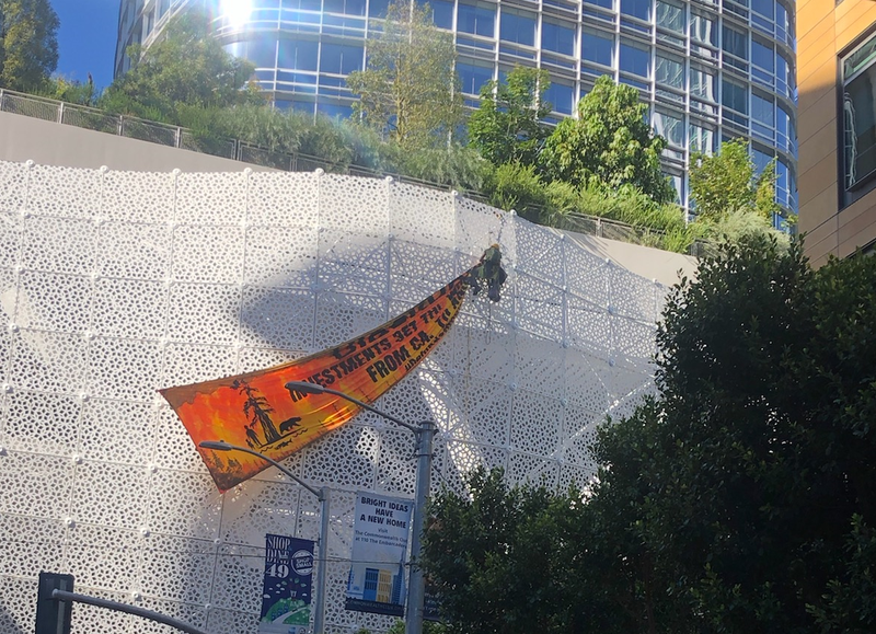 Protesters hang a banner across the side of the Salesforce Transit Center in San Francisco on Friday.