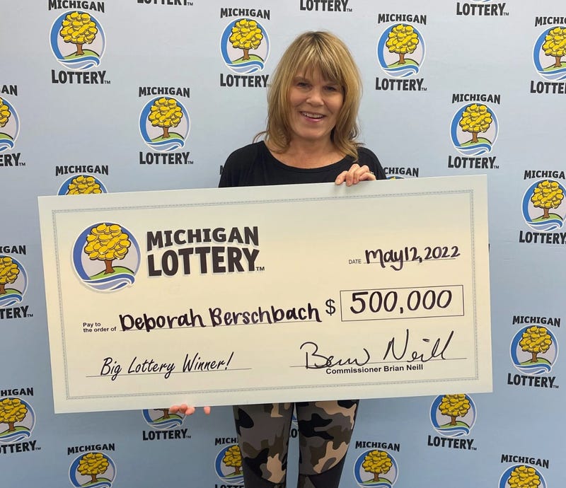 Michigan Lottery winner holding check