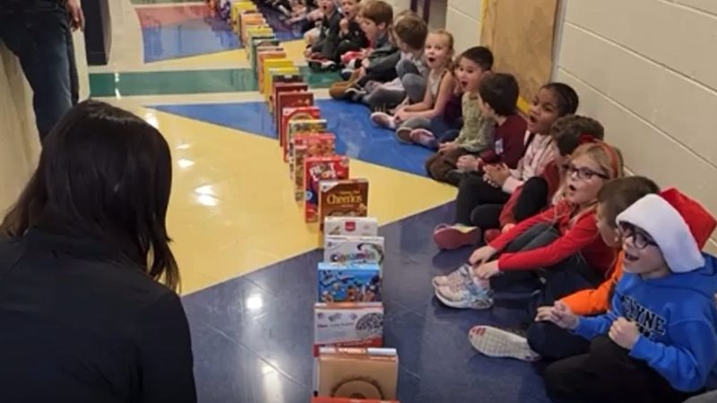 Children cheer during a cereal domino rally
