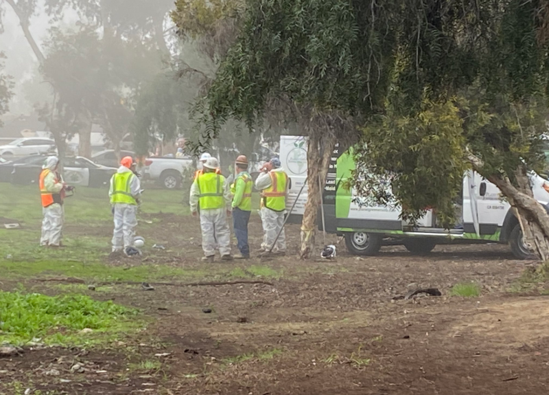 CHP officers in Hazmat suits get ready to clean up the freeway.