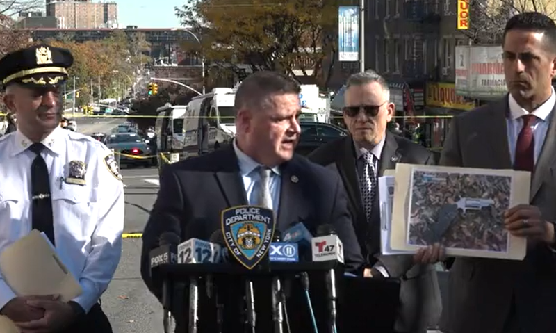 Police officials hold up an image of the gun they say officers recovered at the scene of the shooting.