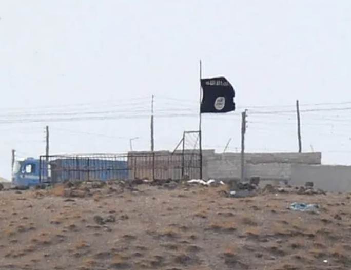 An Islamic State (ISIS) black flag flies near the Syrian town of Kobani, October 27, 2014 as seen from the Turkish-Syrian border near the southeastern town of Suruc in Sanliurfa province, Turkey.