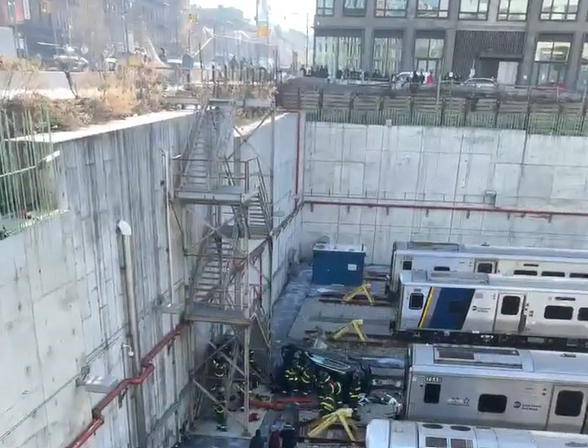 Workers surround the area where the car crashed into the trainyard.