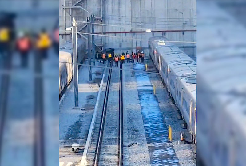Workers surround the area where the car crashed into the trainyard.