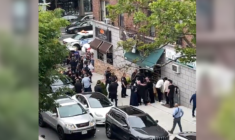 Police gathered around the area where two men were slashed on Saturday.