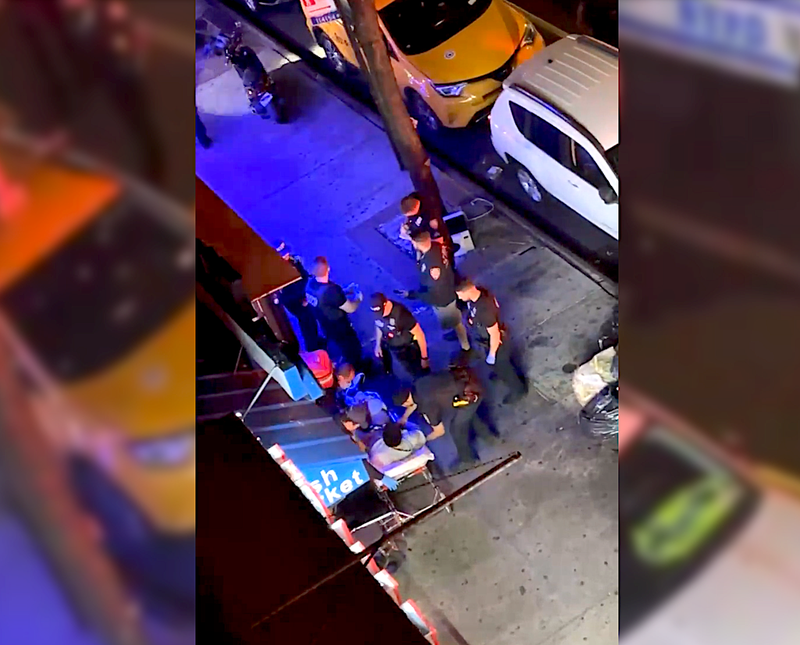 EMS tends to a man on a stretcher outside the Calle 191 Pescaderia fish market