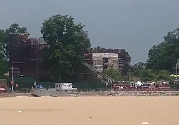 FDNY emergency responders deploy an aerial ladder to rescue two construction workers trapped under a collapsed concrete ceiling.