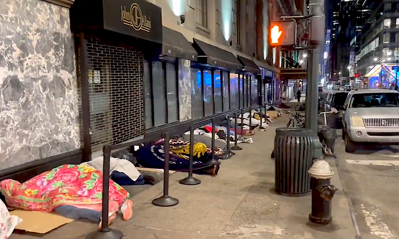 The migrant men have been sleeping for days on the sidewalk