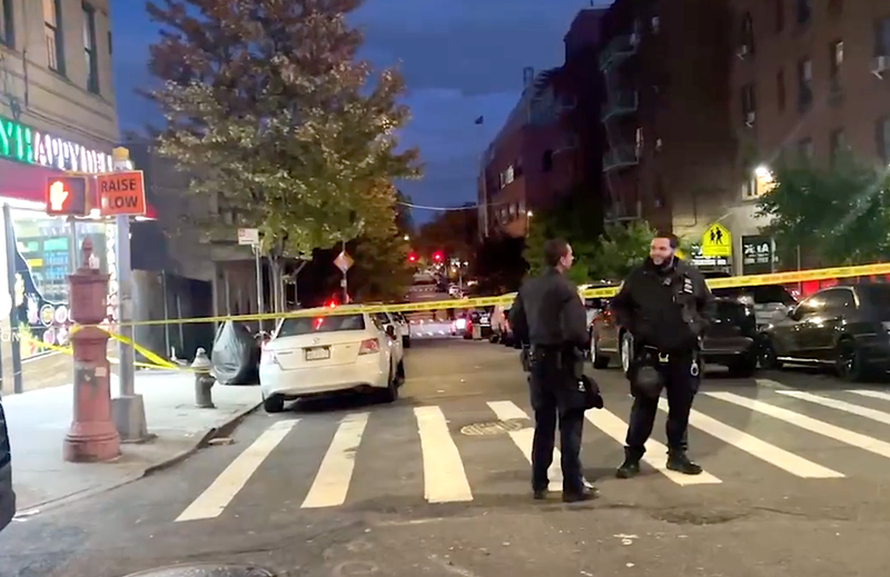 NYPD officers cordon off a street near the shooting scene on Sunday evening