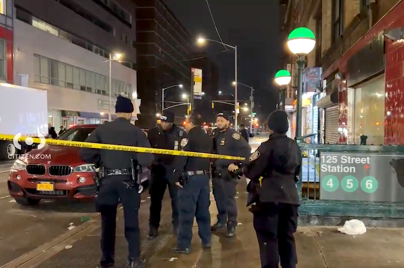 aNYPD officers are seen outside the East Harlem station where a man was shot early Friday