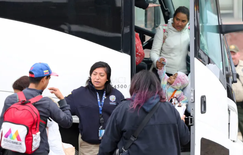 A group of migrants arrive by bus near a Greyhound station in Chicago after being transported from Texas in October 2023.
