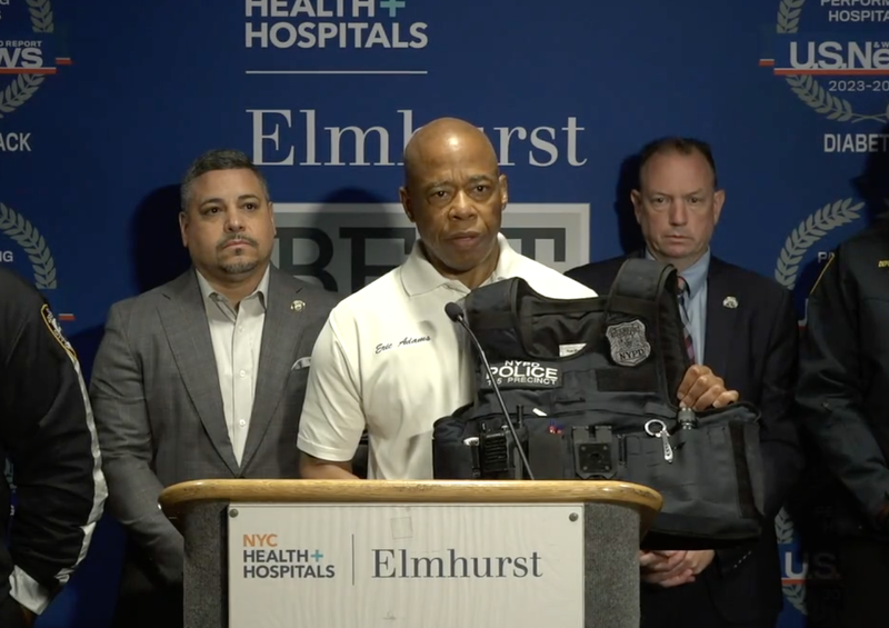 Mayor Adams holds up a bulletproof vest worn by one of the officers who was shot, saying it saved his life