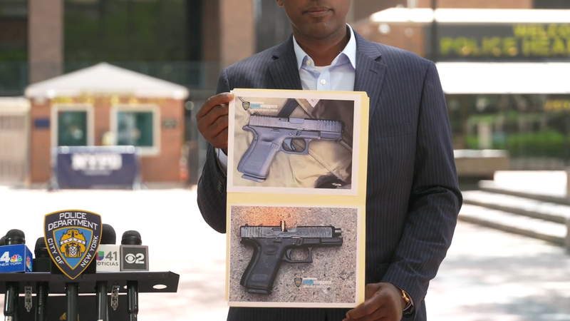 Photos of the two firearms are displayed at an NYPD press conference