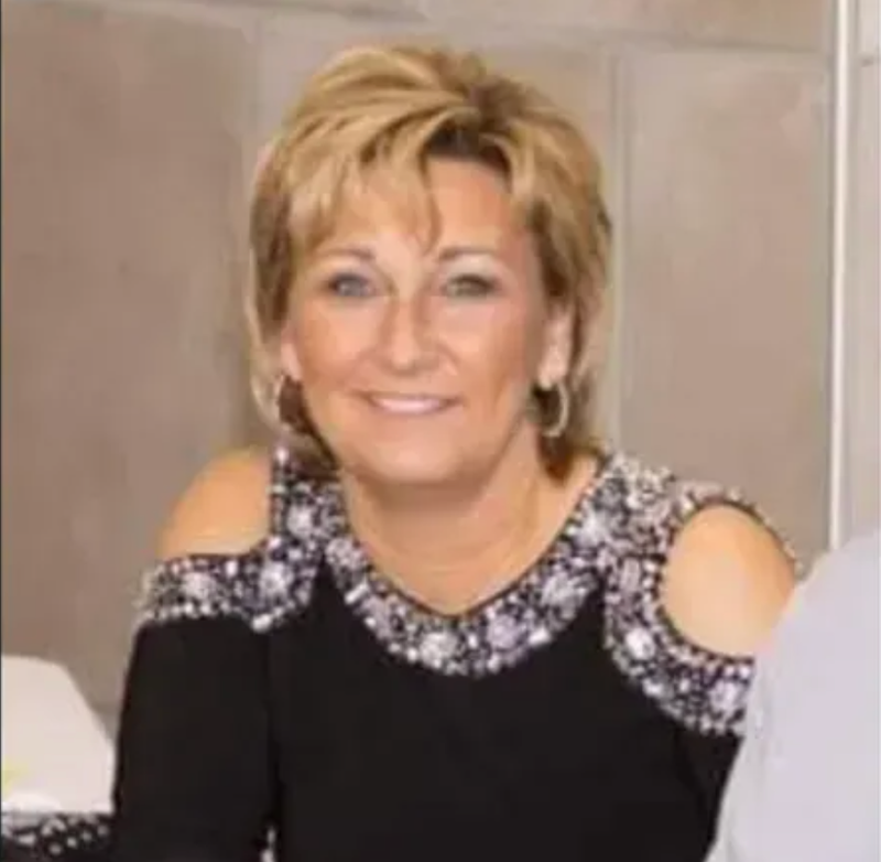 Woman in fancy black top, short blond hair