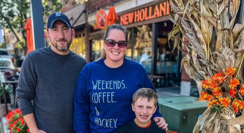 Family of three in front of fall scenery