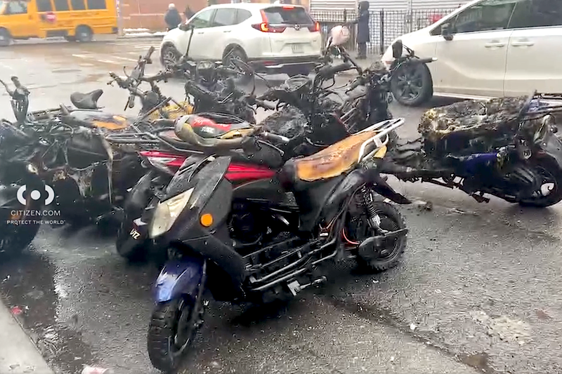 The charred remains of vehicles were gathered on the street outside
