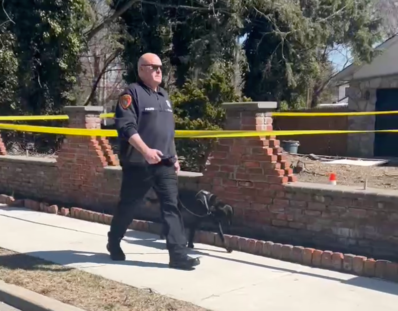 A police officer and canine are seen near Bruno Lane in Dix Hills amid the investigation on March 19