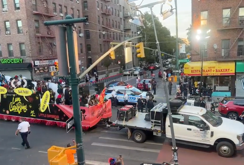 A parade float passes a shooting scene after the parade Monday