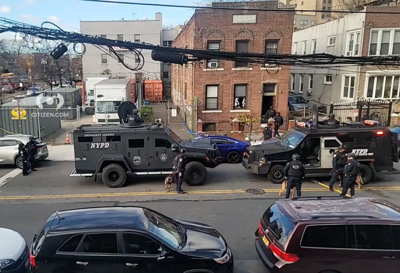 NYPD officers are seen outside of the home in Brownsville on Monday