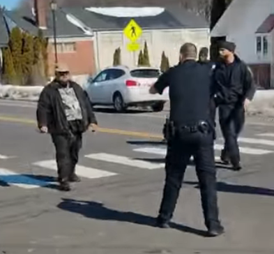 A Facebook video image of a man with a knife, at left, slowly approaching a Hartford police officer on Blue Hills Ave. The officer opened fire, striking the man, who was in critical condition at last report, 2/27/26