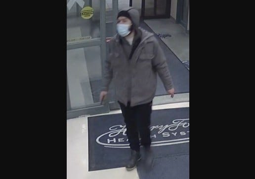 Man wearing black pants, grey coat and hood