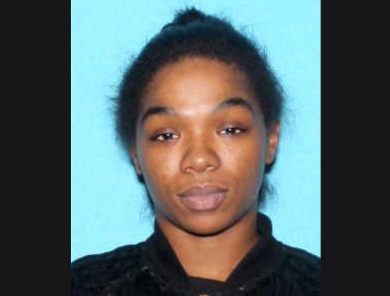 Black woman in her 20s with brown eyes black shirt and black hair pulled back 