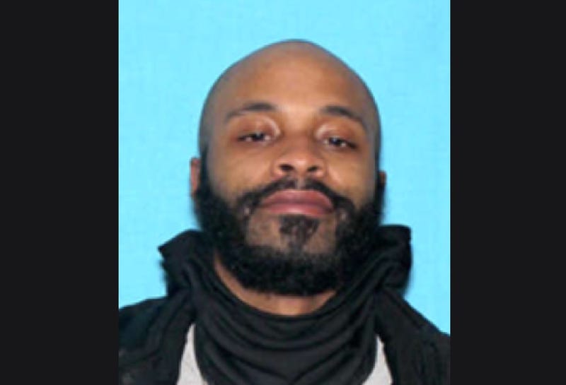 Black man in his 20s with black beard and bald head