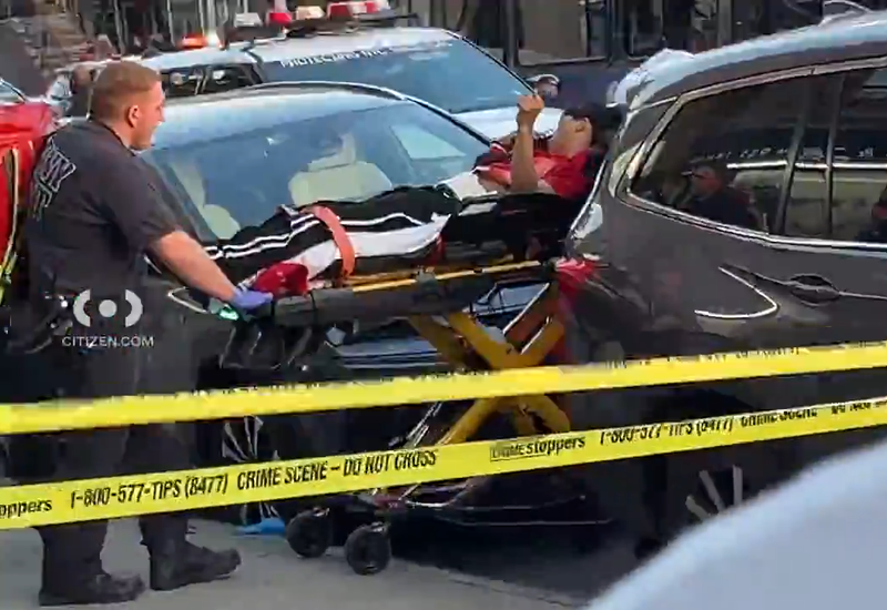 A man is wheeled from the scene on a stretcher