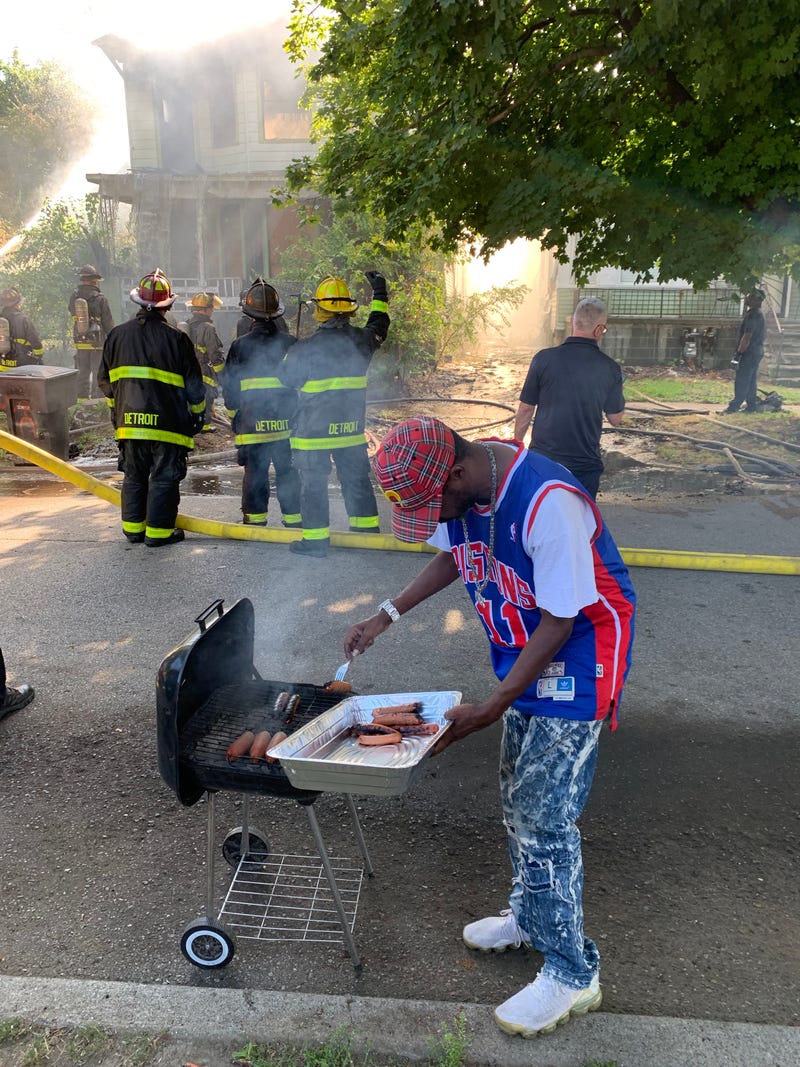 Man cooking hot dogs near Detroit house fire