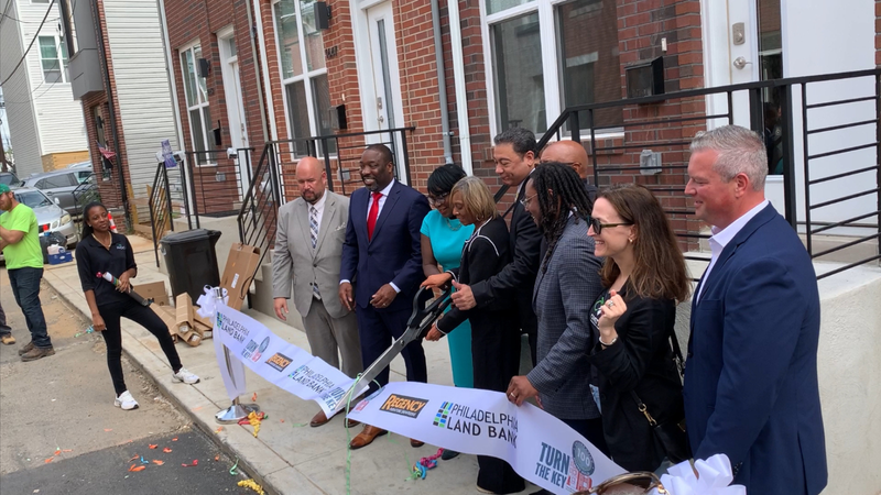 City Officials cut the ribbon in front of Kenya Hinton's new house in Brewerytown, the 100th in the city's Turn the Key program.