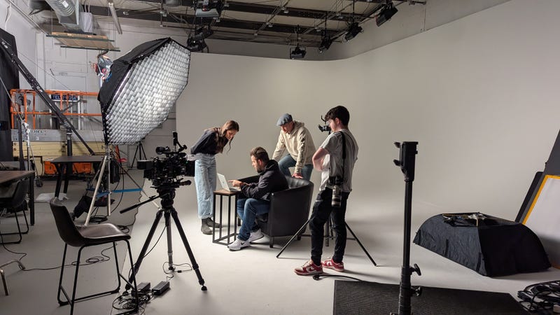 The film crew on the set of Queen of the Base at Stage 27 examines a computer that will be in the next shot.