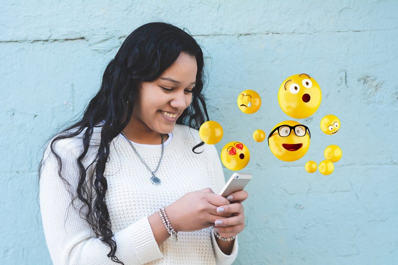 Girl texting using emojis