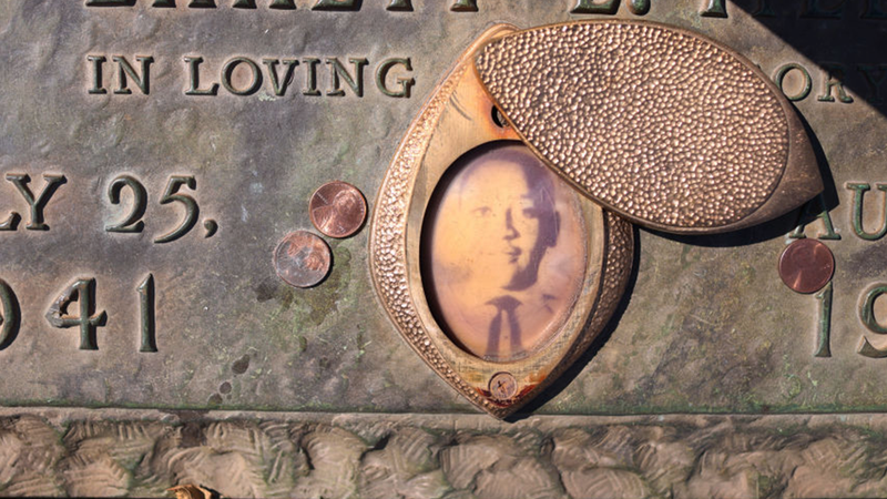 FILE - A faded photograph is attached to the headstone that marks the gravesite of Emmett Till in Burr Oak Cemetery on March 22, 2021 in Chicago, Illinois. Till's brutal murder in Money, Mississippi in the summer of 1955 and his mother's decision to hold an open-casket funeral to expose the brutality of the murder is credited with igniting the modern civil rights movement.   
