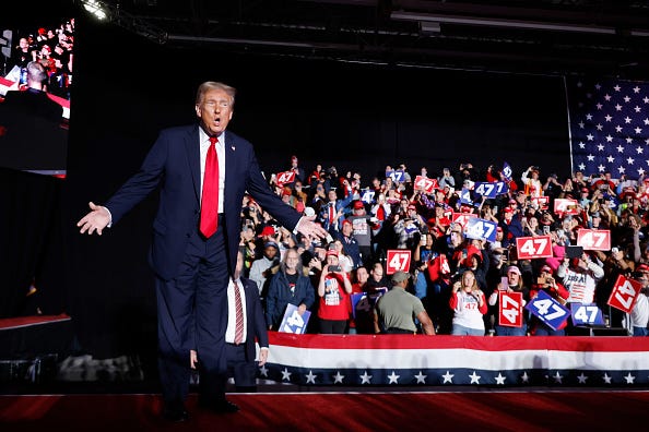 Presidential Candidate Trump stands in front of a crowd of supporters at a 2024 Michigan campaign rally