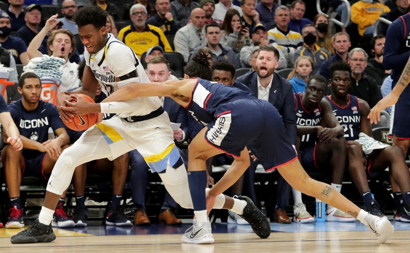 Connecticut guard Andre Jackson (44) tries to rip the ball away from Marquette forward Olivier-Maxence Prosper (12) during the first half.