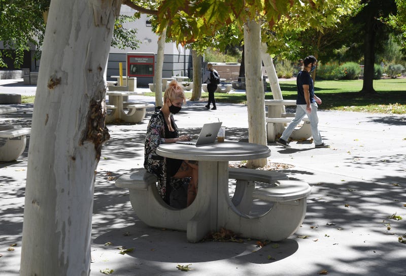 A student works on a laptop in a courtyard at UNLV