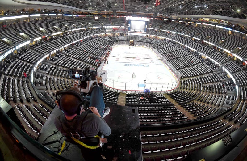 A television network cameraman relaxes in an upper deck location