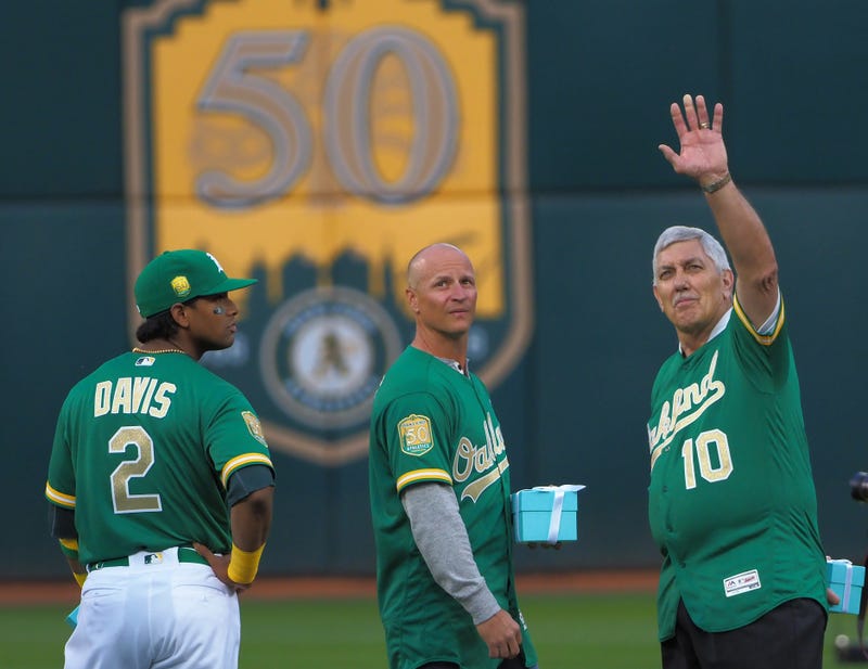 Oakland Athletics designated hitter Khris Davis (2) and former player Mark Ellis and former player Ray Fosse react during a presentation to recognize the 50th anniversary team at Oakland Coliseum.