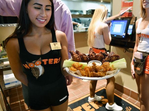 Hooters waitress Liberty Phan carries out a Buffalo Platter of wings Friday afternoon and the new restaurant on Call Field Road.