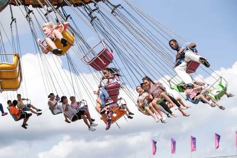 People ride a carnival ride at the Michigan State Fair