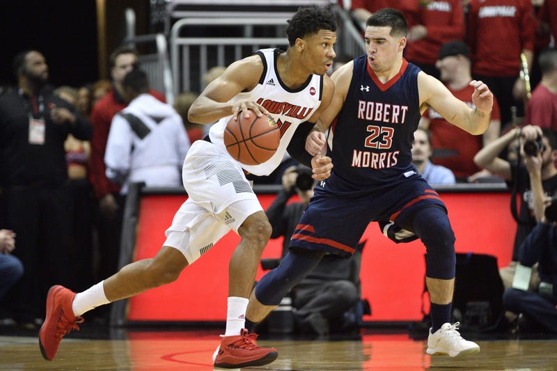Louisville Cardinals forward Dwayne Sutton (24) dribbles the ball around Robert Morris Colonials guard Matty McConnell (23)