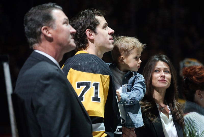 Pittsburgh Penguins owner Mario Lemieux (left) watches a video tribute honoring the 1000th career NHL point of center Evgeni Malkin (