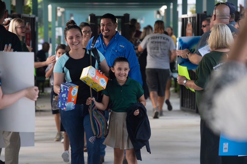 girls arrives to school with mother