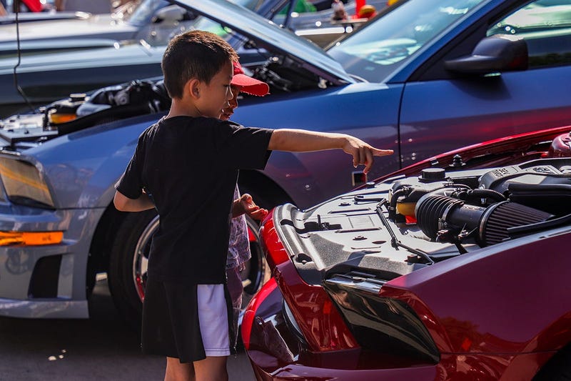 Darren Li, 7, of Troy looks at a Ford Mustang engine with classmate Aadit Rajpathak, 6, of Troy, during the 2019 Woodward Dream Cruise in Ferndale, Mich. on Saturday, Aug. 17, 2019. Dreamcruise 081719 427