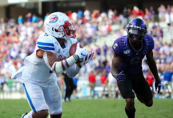 outhern Methodist Mustangs running back Xavier Jones (5) catches a touchdown pass past TCU Horned Frogs safety Innis Gaines (6) during the second half at Amon G. Carter Stadium