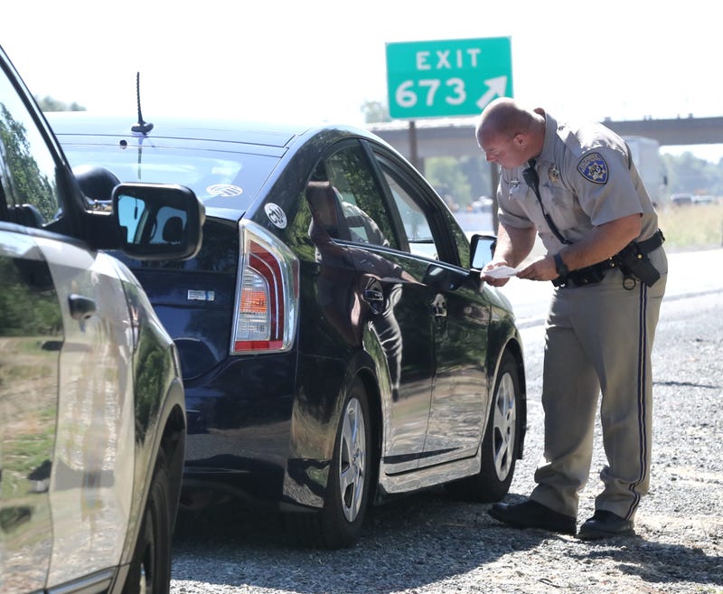 California Highway Patrol officer Jason Morton tickets a driver on Interstate 5 who went over the 55-mph speed limit on Monday, Aug. 26, 2019, in the work zone of the Redding to Anderson six-lane expansion project. Redding to Anderson Six Lane Expansion Project