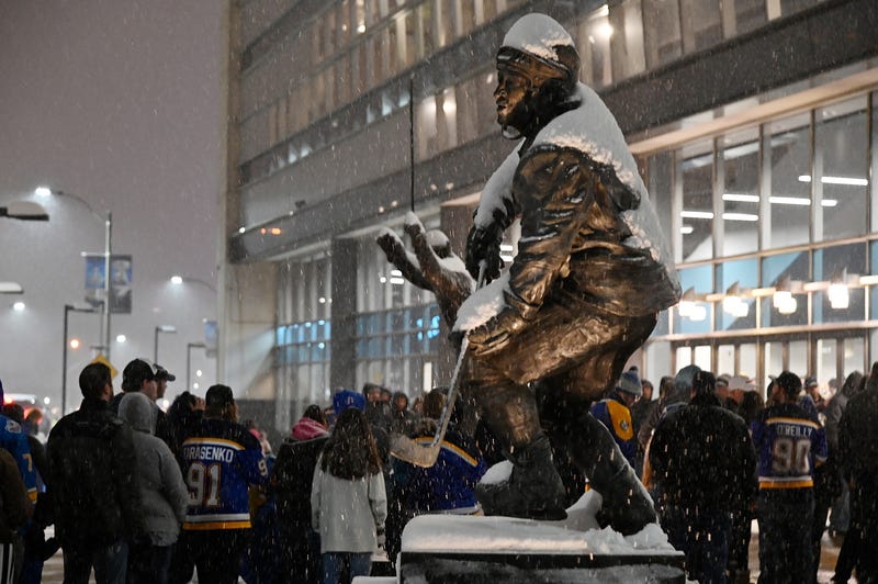 Fans wait in line to enter the Enterprise Center as snow falls prior to a game between the St. Louis Blues and the Colorado Avalanche.  