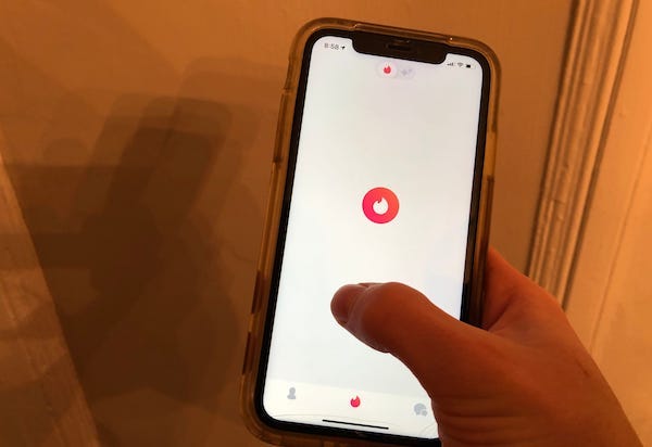 Person tapping on Tinder dating app