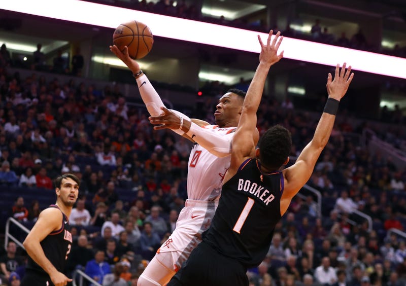 Russell Westbrook lays it in over Devin Booker of the Suns.